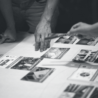 Mains visible autour d'une table lors d'un atelier de la Fresque du Numérique